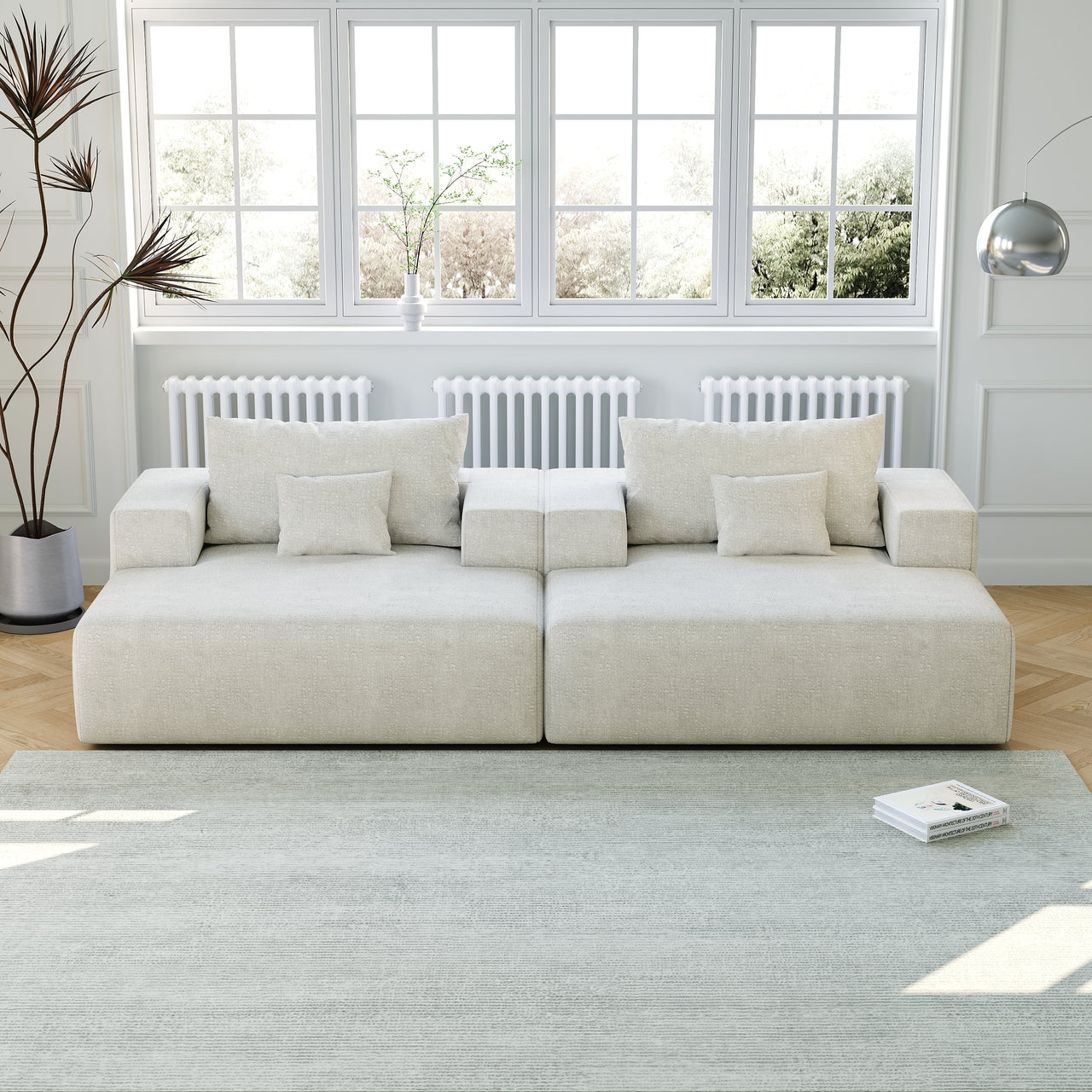 Dark green modular sofa with three cushions on a wood floor near large windows
